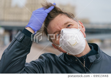 Man wearing protective mask outdoors. Coronavirus pandemic time. Man wearing protective mask outdoors. Coronavirus pandemic time. 69913448
