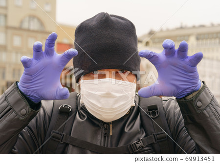 Man wearing protective mask outdoors. Coronavirus pandemic time. Man wearing protective mask outdoors. Coronavirus pandemic time. 69913451
