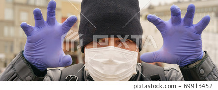 Man wearing protective mask outdoors. Coronavirus pandemic time. 69913452