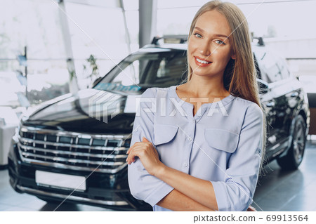 Young woman checking out a new car she is going to buy Young woman checking out a new car she is going to buy 69913564