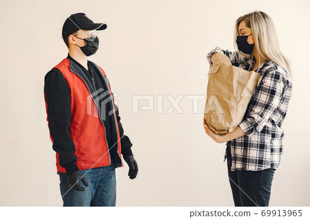 Delivery man in a medic mask with woman Delivery man in a medic mask with woman 69913965