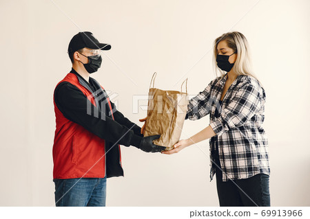 Delivery man in a medic mask with woman 69913966