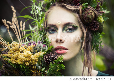 Fairy nymph woman with flowers outdoors. Halloween character or Forest soul 69913984