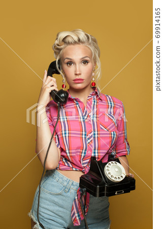 Shocked Pin-up woman answers a phone call 69914165
