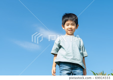 Boy taking a walk under the blue sky Boy taking a walk under the blue sky 69914333