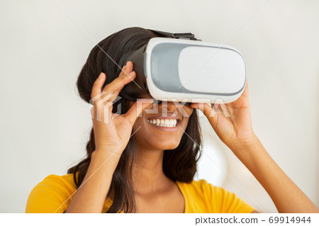 Futuristic technologies in everyday life. Happy black lady wearing VR headset and enjoying cyberspace exploration 69914944
