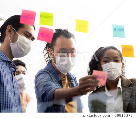 Interracial business team wear face mask brainstorm at new normal office 69915372