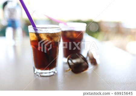 Table two dark colored cocktails with straw Table two dark colored cocktails with straw 69915645