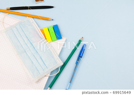 School supplies with a mask on a blue background. School supplies with a mask on a blue background. 69915649