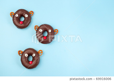 Christmas reindeers made from chocolate doughnut, pretzel cookie, marshmallow and candy, Christmas background with copy space, horizontal 69916006