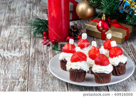 Santa made from chocolate muffin, whripping cream and strawberry, Christmas menu for kids or party, horizontal, copy space Santa made from chocolate muffin, whripping cream and strawberry, Christmas menu for kids or party, horizontal, copy space 69916008