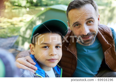 Father and Son Taking Selfie Outdoors 69916196