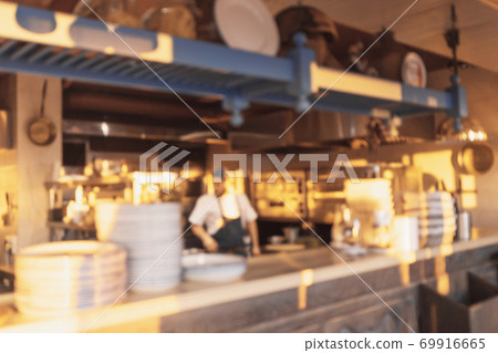 Seafront mediterranean cafe kitchen brightly lit by setting sun. Defocused background. 69916665