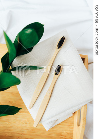 Toothbrushes made of natural bamboo close-up close with green leaves 69916955