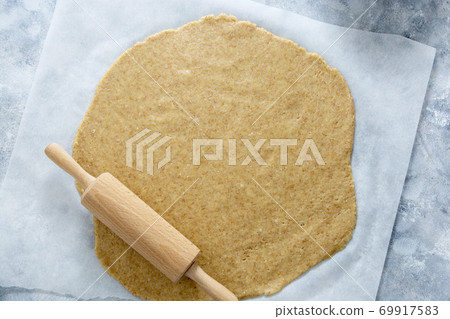Rolled out pie or cookies dought on baking paper. Top view. 69917583