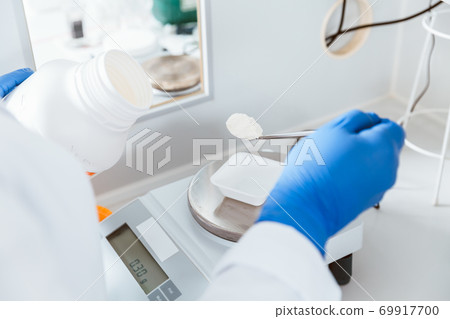 Pharmacist weighing chemical 69917700