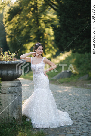 Young female model in wedding dress outdoors. Fashion photo of bride Young female model in wedding dress outdoors. Fashion photo of bride 69918310