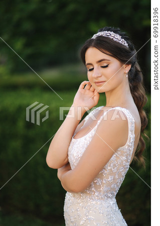 Portrait of young bride in white wedding dress outdoors. Fashion makeup Portrait of young bride in white wedding dress outdoors. Fashion makeup 69918396