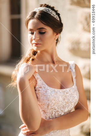 Portrait of young bride in white wedding dress outdoors. Fashion makeup Portrait of young bride in white wedding dress outdoors. Fashion makeup 69918446