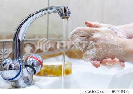 The girl washes her hands with soap under the tap with water. Personal hygiene. Disinfection. Hygiene concept. Corona virus Prevention to stop spreading coronavirus. 69918483