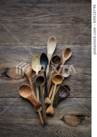 Top view lot of wooden spoons made of precious wood on wooden table, eco-friendly concept of cutlery, handmade tableware production Top view lot of wooden spoons made of precious wood on wooden table, eco-friendly concept of cutlery, handmade tableware production 69918746