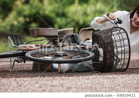 Woman falling down on a bicycle 69919421