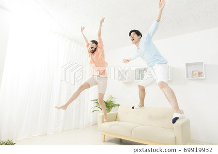 Couple jumping on the couch Couple jumping on the couch 69919932