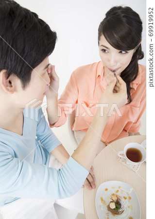 Couple feeding each other cake 69919952