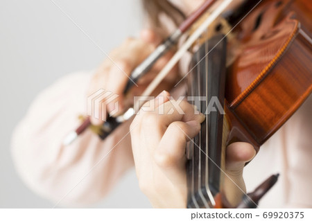 A woman playing a violin 69920375