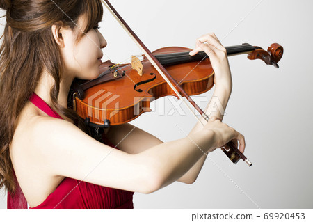 A woman playing a violin 69920453