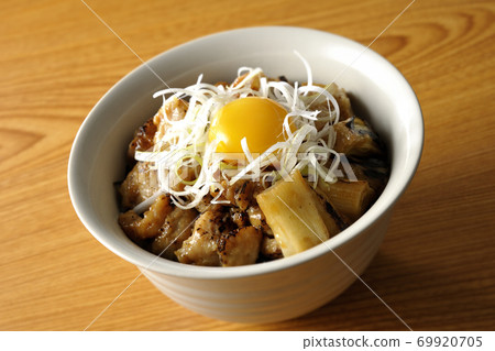 A bowl of white-haired green onions and egg yolk on top of a charcoal-grilled yakitori 69920705