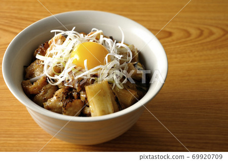 A bowl of white-haired green onions and egg yolk on top of a charcoal-grilled yakitori 69920709
