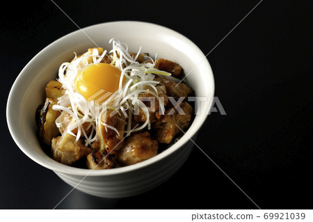 A bowl of white-haired green onions and egg yolk on top of a charcoal-grilled yakitori (black background) 69921039