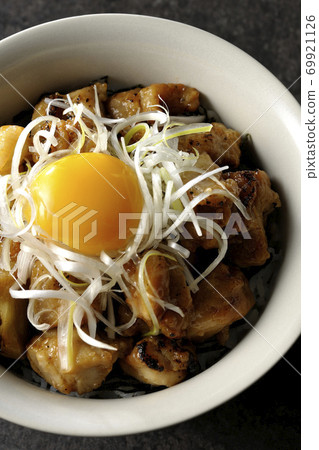 Donburi with white-haired green onions and egg yolk on top of yakitori grilled over charcoal (overhead view) 69921126