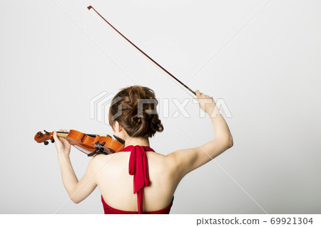 Back view of a woman playing the violin Back view of a woman playing the violin 69921304