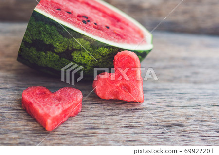 Healthy watermelon smoothie with mint, a piece of watermelon, hearts and a striped straw on a wood background Healthy watermelon smoothie with mint, a piece of watermelon, hearts and a striped straw on a wood background 69922201