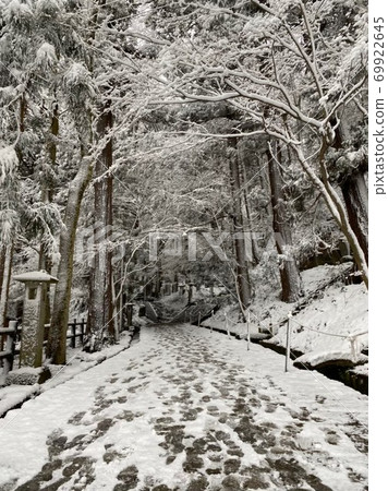 Let's walk along the narrow path behind the snowy landscape 69922645