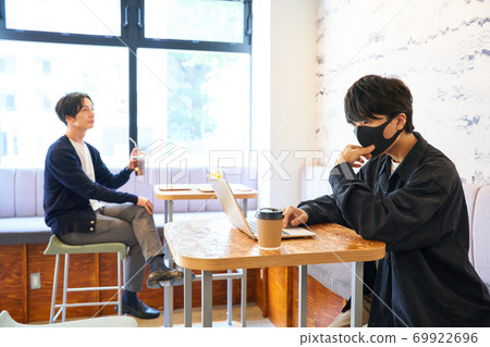 Men and women relaxing in a cafe Men opening a computer in a cafe Men and women relaxing in a cafe Men opening a computer in a cafe 69922696