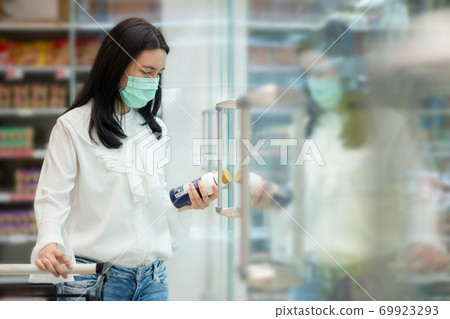 Asian woman wearing face mask and choosing milk 69923293