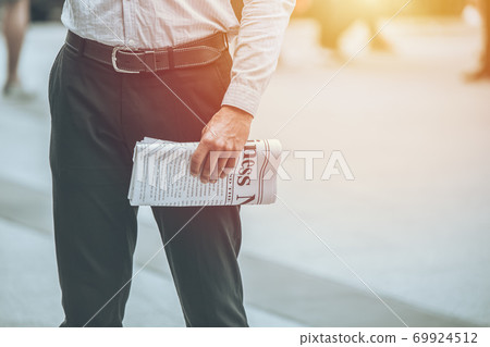 Businessman hand holding mockup fake business news paper for read every morning day 69924512