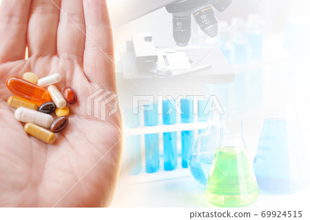 Group of medical pill on hand with science lab medical research on background space for text. 69924515