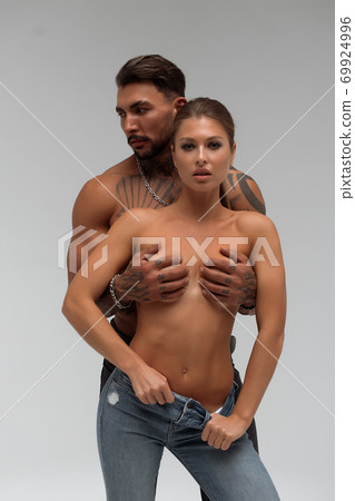 Muscular man hugging topless woman 69924996