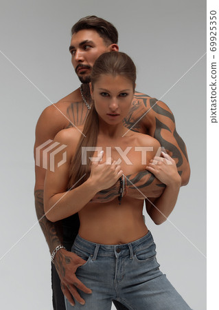 Muscular man hugging topless woman 69925350