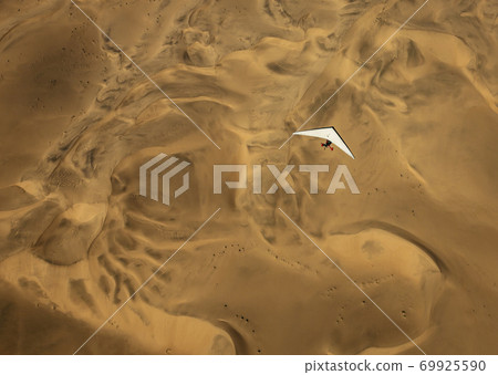 A microlight aircraft can be seen flying over the sands of Namibia A microlight aircraft can be seen flying over the sands of Namibia 69925590