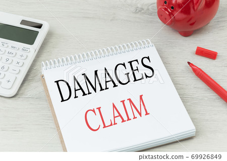 Damages claim text on notepad with calculator Damages claim text on notepad with calculator 69926849