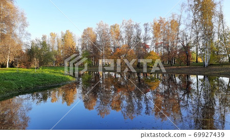 Autumn in a city park with a small lake on a sunny day 69927439
