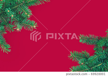 Christmas composition with border of green fir branches on red background 69928001