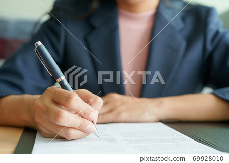 Close-up of hand female customer signs a sales contract are doing business in the office 69928010