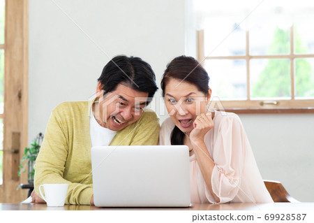 一對六十多歲的夫婦和朋友一起看電腦 69928587