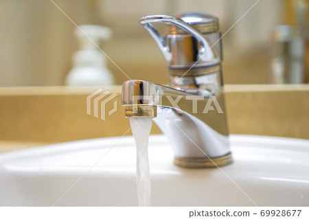 Water coming out of the washbasin faucet 69928677